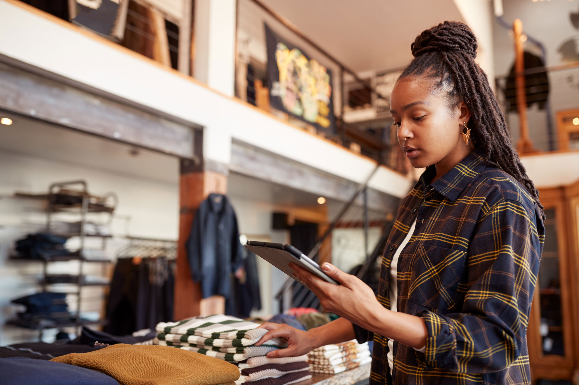 Retail associate reviewing inventory on a tablet in a consumer goods store