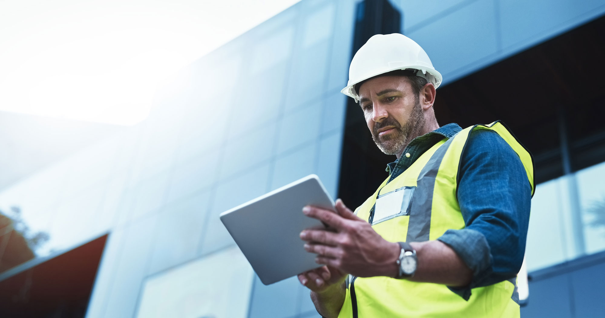 Construction site supervisor reviewing project data on a tablet