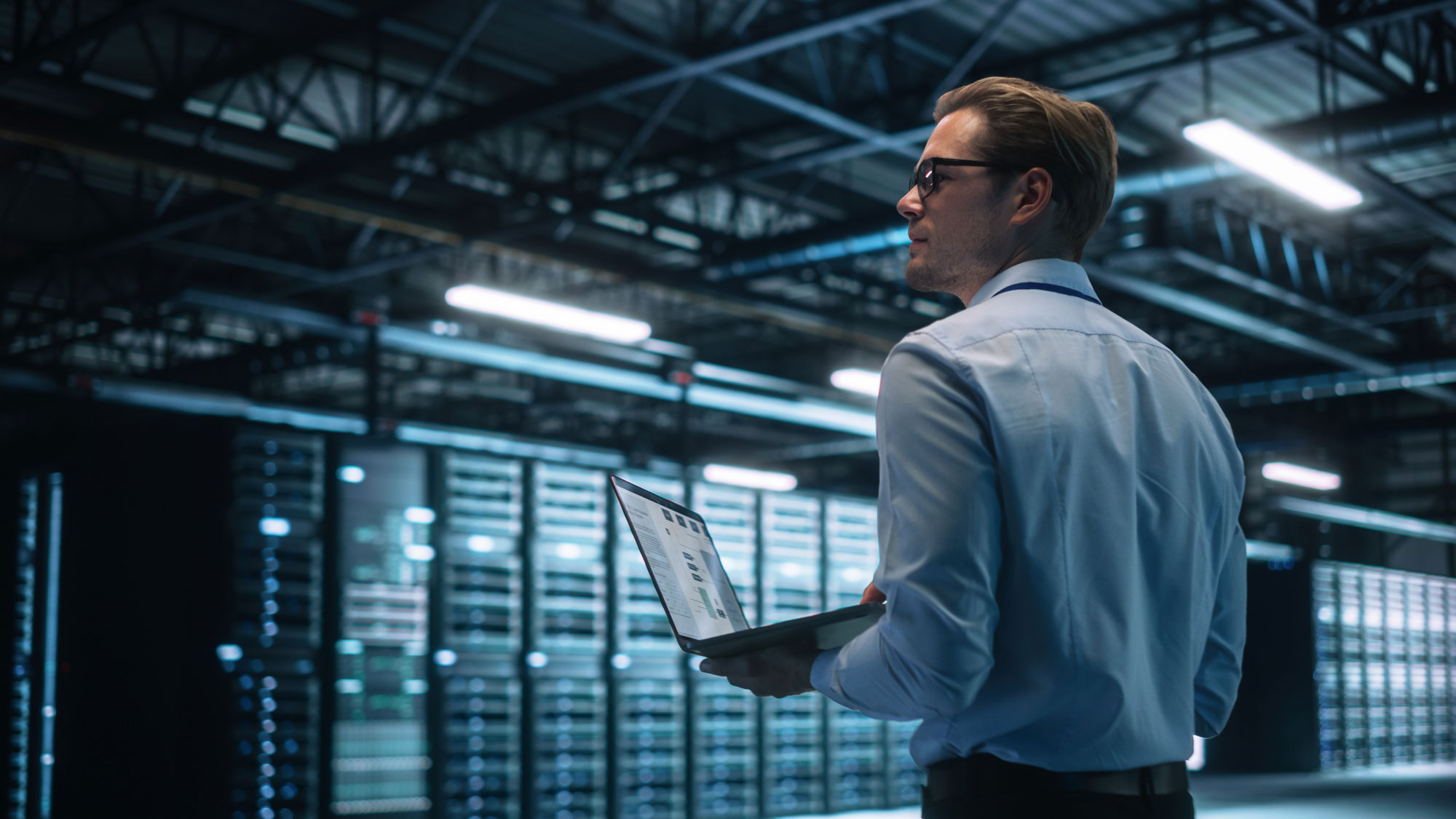 Engineer in a high-tech network operations centre reviewing telecoms infrastructure